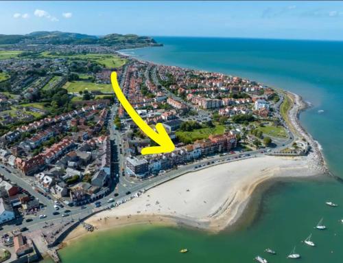 an aerial view of a beach with a yellow arrow at Stunning 2 Bedroom Beach Apartment With Garden in Rhos-on-Sea