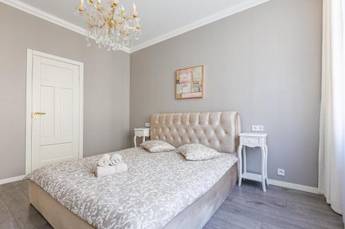 a bedroom with a bed and a chandelier at Amber Apartment in Riga