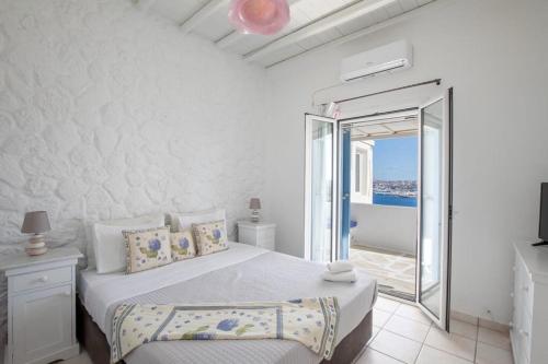 a bedroom with a bed with a view of the ocean at Villa BiancaRosa with amazing views! in Mikonos