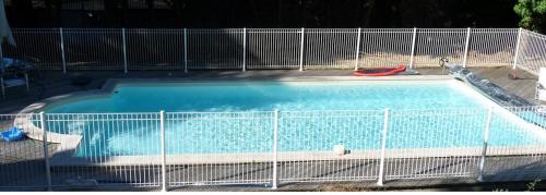a large swimming pool with a fence around it at Gîte des trois pommes in Mauléon