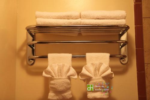 a towel rack with towels and shoes in a bathroom at Arcadia Hotel in Gering