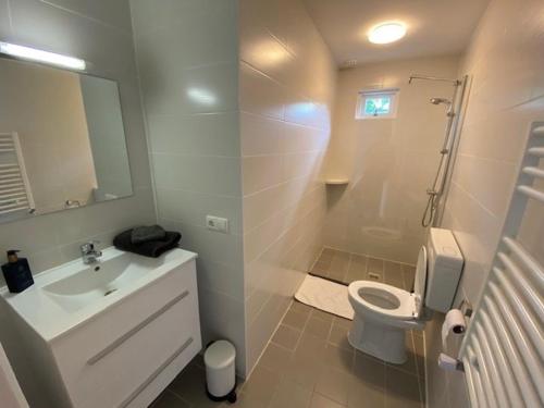 Un baño blanco con lavabo e inodoro. en BY BABS guesthouse Bergen nh, en Bergen