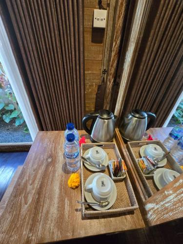 a table with dishes and a bottle of water on it at Aura Guesthouse in Ubud