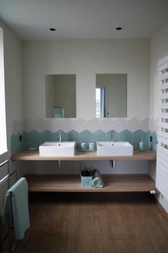 a bathroom with two sinks and a large mirror at Douce Escapade à Chaintré in Chaintré
