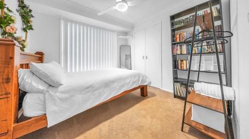 a bedroom with a bed and a book shelf at Blue Willow Bathurst Country Getaway in Bathurst