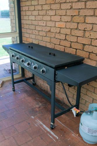 a black barbecue grill sitting next to a brick wall at Blue Willow Bathurst Country Getaway in Bathurst