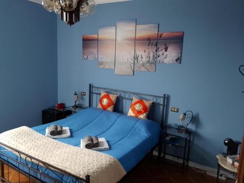 Un dormitorio azul con una cama con toallas. en il Cantuccio, en Desenzano del Garda