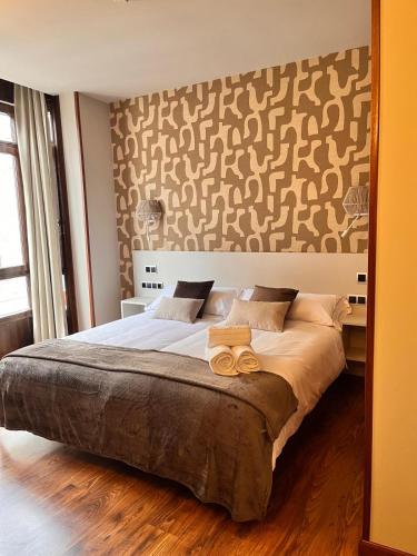 a bedroom with a large bed with a headboard at Hotel Boutique Villa de Noreña in Noreña
