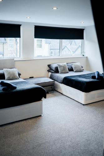 zwei Betten in einem Zimmer mit zwei Fenstern in der Unterkunft Modern 5 Bedroom Terraced Luxurious House in Colwyn Bay