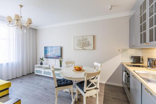 a kitchen and dining room with a table and chairs at Elegant Apartment in Rīga