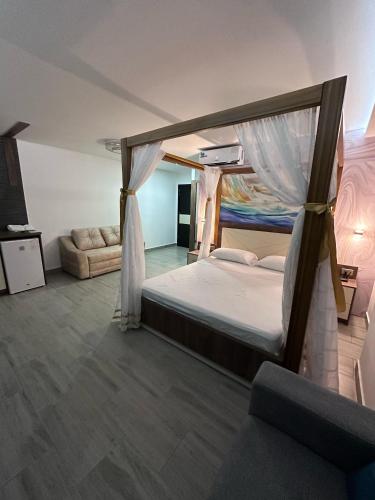 a bedroom with a canopy bed and a couch at Hotel Playa Dubai Golden Suite in Cojimíes