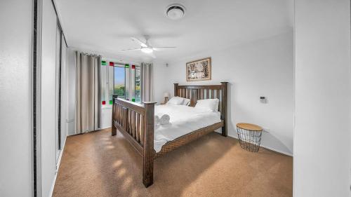 a bedroom with a bed with white sheets and a window at Blue Willow Estate Bathurst in Bathurst