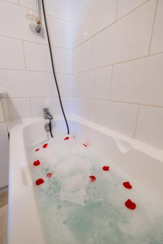 d'une baignoire remplie d'eau et de fleurs rouges. dans l'établissement Appartement climatisé avec la terrasse, deux pas du métro, Stadium, Toulouse, à Toulouse