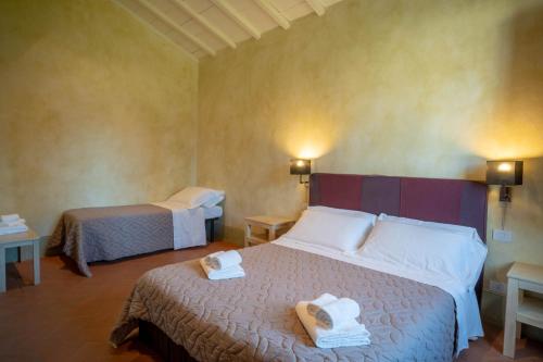 a hotel room with two beds with towels on them at Tenuta San Jacopo - Agriturismo in Cavriglia