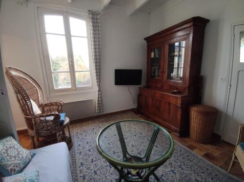 een woonkamer met een salontafel en een tv bij Villa de la fontaine vue mer in Paimpol