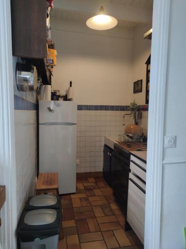 Elle comprend une petite cuisine avec un réfrigérateur blanc et des toilettes. dans l'établissement Villa de la fontaine vue mer, à Paimpol