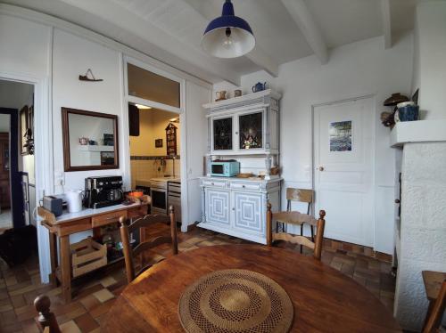 een keuken met een tafel en een keuken met een aanrecht bij Villa de la fontaine vue mer in Paimpol