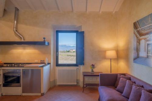 a kitchen and living room with a couch and a window at Tenuta San Jacopo - Agriturismo in Cavriglia