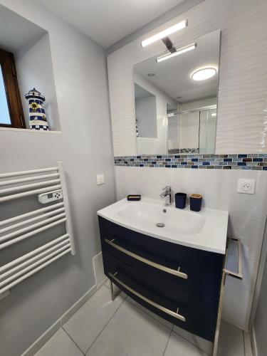 une salle de bain avec un lavabo et un miroir dans l'établissement La Ferme Saint Jean, à Pontorson