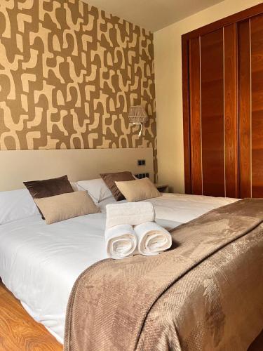 a bedroom with two white towels on a bed at Hotel Boutique Villa de Noreña in Noreña