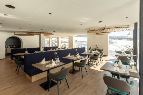a restaurant with tables and chairs in a room at Hotel Alpenrose in San Valentino alla Muta
