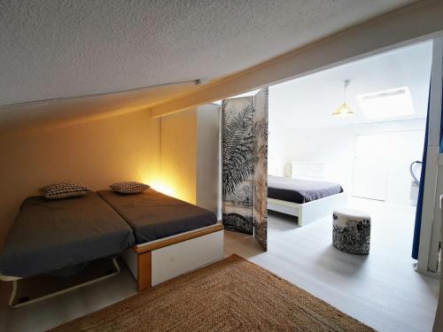 une petite chambre avec un lit et un miroir dans l'établissement Uhaina, Maison proche Golf et Plage, à Moliets-et-Maa