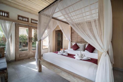 a bedroom with two beds with drapes at Uma Caming Villa Ubud in Tegalalang