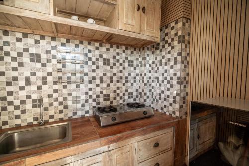 a kitchen with a sink and a stove on a counter at Uma Caming Villa Ubud in Tegalalang