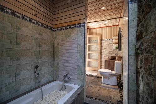 a bathroom with a tub and a toilet at Uma Caming Villa Ubud in Tegalalang