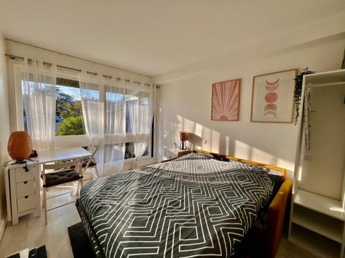 ein Schlafzimmer mit Bett, Schreibtisch und Fenster in der Unterkunft HanaHome 2 adultes parking privé business & tourisme in Le Chesnay