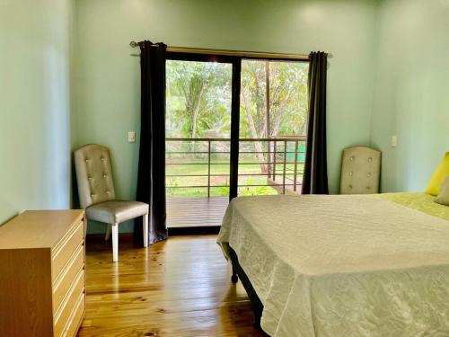 a bedroom with a bed and a window with a balcony at Casa Morpho in Zancudo