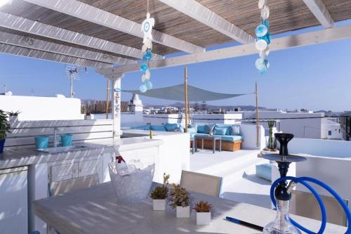 a patio with a table and chairs on a roof at Sandora in Agios Prokopios