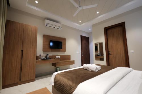 a bedroom with a bed and a sink and a television at Hotel Regal Palm in Morādābād