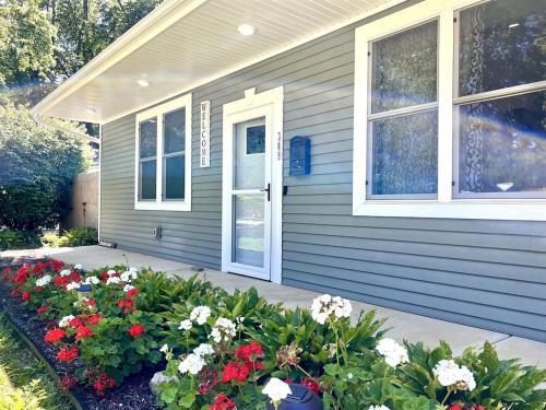 une maison avec des fleurs rouges et blanches devant elle dans l'établissement Central Location, Hot tub, Digital Game Table, à Normal