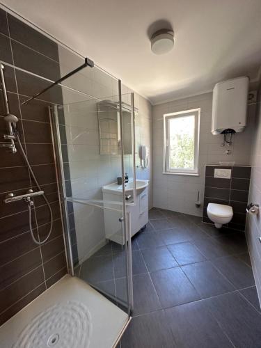 a bathroom with a shower and a sink and a toilet at Apartments Villa Eva in Slano