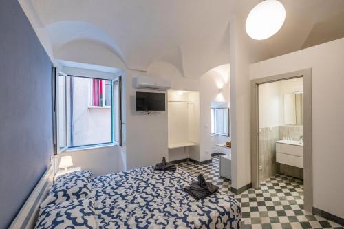 una piccola camera da letto con un letto e un bagno di Il Pesciolino Blu a Finale Ligure