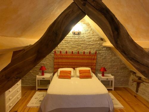 une chambre avec un lit dans un grenier dans l'établissement Mas d'Ambayrac chambres d'hôte Le four a pain, à Promilhanes