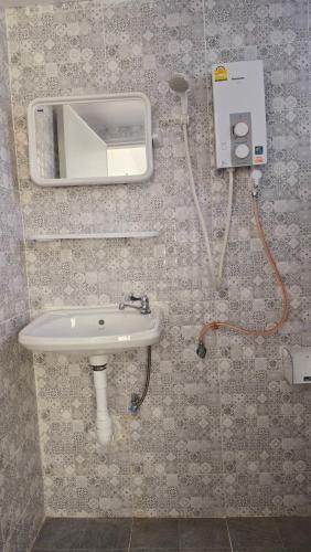 a bathroom with a sink and a mirror on the wall at Smile house 354 in Chiang Rai