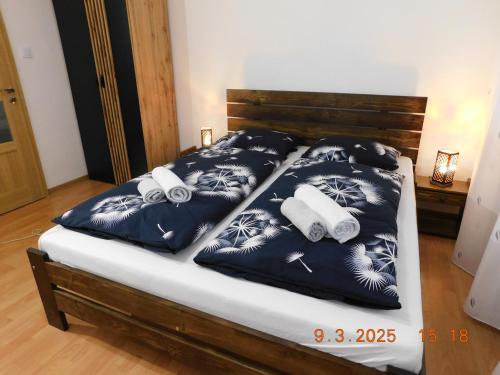 a bed with black and white sheets and towels at Pod Dubom in Liptovský Mikuláš