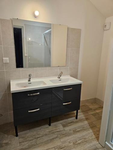 une salle de bain avec un lavabo et un miroir dans l'établissement maison de campagne, à Saint-Léger