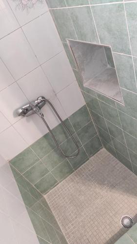 a shower in a bathroom with green and white tile at Family House , Amazing Sea View in Kamarai