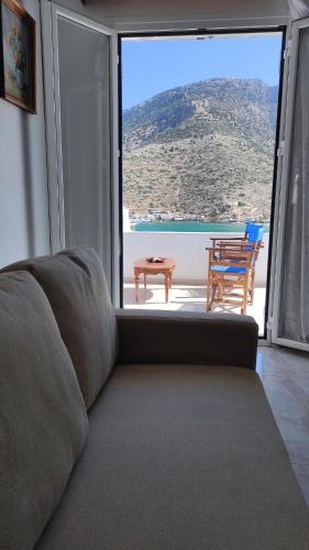 a couch in a living room with a large window at Family House , Amazing Sea View in Kamarai