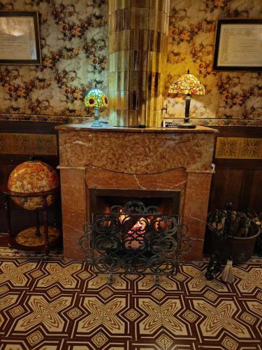 a living room with a fireplace and a chair at Els Jardins De La Martana in Besalú