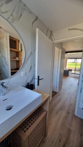 une salle de bain avec un lavabo et un miroir dans l'établissement Maison 2-6 Personnes, à Campbon
