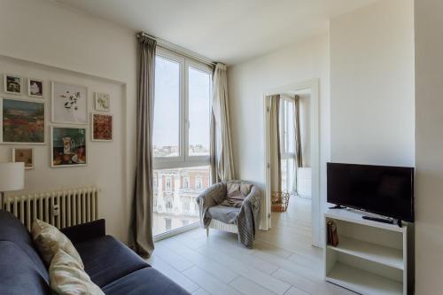 a living room with a blue couch and a television at Yourbanflat Eremitani in Padova
