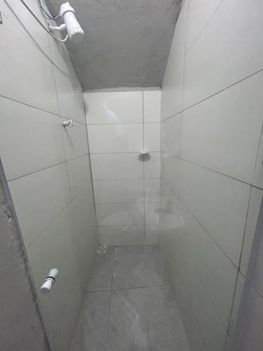 a bathroom with a shower with white walls at Loft confortável com Self Cheking in Joinville