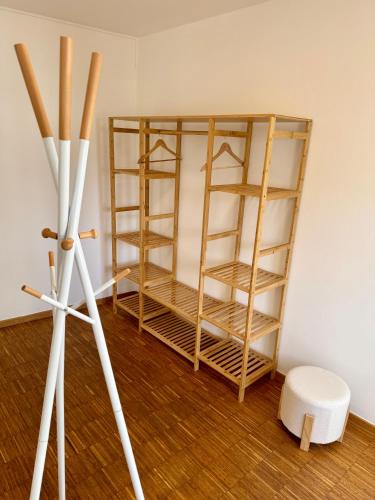 a white tripod next to a room with wooden shelving at "Cooles Ferienhaus!" - im Coburger Wonderland - Ihr Zuhause auf Zeit! in Coburg
