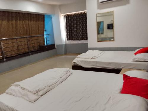 a room with two beds and a window at Infinity Rooms D-Mart in Surat