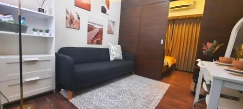 a living room with a blue chair and a desk at Air Residences-Stylish&Comfort Stay High flat with balcony in Manila