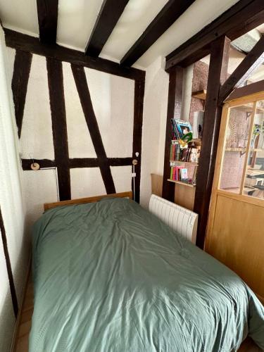 - une chambre avec un lit dans une pièce dotée de poutres apparentes dans l'établissement L atypique de bourbonnoux, à Bourges